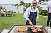Australian Prime Minister Anthony Albanese reacts as he cooks on a barbecue at an event to mark the beginning of the social media ban for children under 16 years of age, at Kirribilli House, in Sydney, Australia,