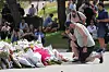 En mann kneler etter å ha lagt ned blomster ved et minnesmerke utenfor Bondi Pavilion på Bondi Beach i Sydney mandag 15. desember 2025, dagen etter den verste masseskytingen i Australia siden 1996.