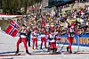 Ungdommer i Team Pølsa krysser målstreken i Holmenkollen mens publikum heier.