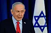 Benjamin Netanyahu taler foran mikrofon med israelsk flagg i bakgrunnen
