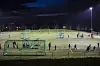 Barn trener fotball på opplyst kunstgressbane på Caltexløkka en mørk kveld.