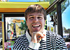 Ramón Torres Andersen smiler i en stripete genser på et fargerikt sted med glassvegger.