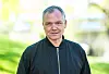 Portrett av Arne Lygre utendørs foran en lys, grønn bakgrunn.