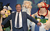 Albert Uderzo står foran Asterix, Miraculix og Obelix ved en prisutdeling.