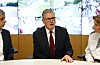 Keir Starmer sitter ved et bord med Sadiq Khan og en politisjef foran skjermer med CCTV-bilder.