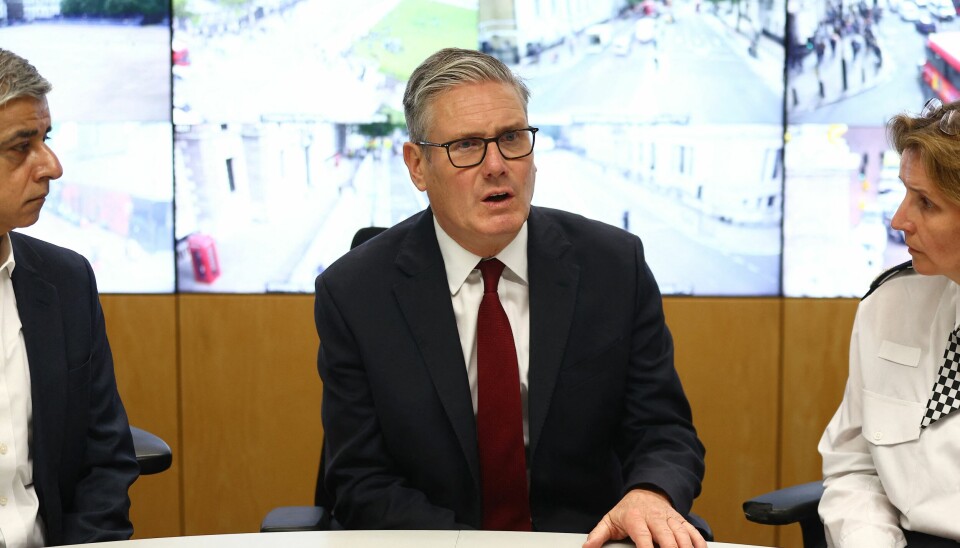 Keir Starmer sitter ved et bord med Sadiq Khan og en politisjef foran skjermer med CCTV-bilder.