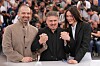 Tre personer poserer med sammenknyttede hender ved et fotoopptak på Cannes-festivalen.