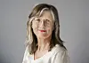 Kvinne med briller og lyst hår foran grå bakgrunn. Birgitte Lange