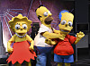 Kostymerte figurer av Lisa Simpson, Homer Simpson og Bart Simpson står sammen ved Empire State Building.