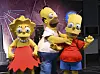 Kostymerte figurer av Lisa Simpson, Homer Simpson og Bart Simpson står sammen ved Empire State Building.