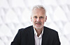 Portrett av Geir Bergkastet foran lys, geometrisk bakgrunn.