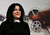 Marjane Satrapi står foran et filmplakatmotiv ved en festivalvegg i Roma.