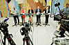 Flere politikere står bak små bord under en pressekonferanse i Stortingets vandrehall, omgitt av TV-kameraer.