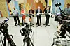 Flere politikere står bak små bord under en pressekonferanse i Stortingets vandrehall, omgitt av TV-kameraer.