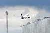 Charterfly tar av ved Gardermoen med terminalbygning og lysmast i forgrunnen.