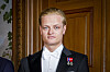 Marius Borg Høiby i smoking foran en tredør, med to jubileumsmedaljer på brystet.