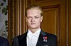 Marius Borg Høiby i smoking foran en tredør, med to jubileumsmedaljer på brystet.