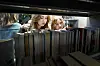 Skoleelever leser ved bokhyller på et bibliotek i Oslo.