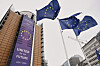 EU-flagg blafrer foran et høyt EU-bygg i Brussel.