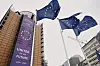 EU-flagg blafrer foran et høyt EU-bygg i Brussel.