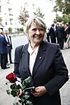 Kirsti Sparboe står foran Frogner kirke i Oslo og holder røde roser under bisettelsen til Rolv Wesenlund.