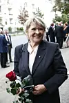 Kirsti Sparboe står foran Frogner kirke i Oslo og holder røde roser under bisettelsen til Rolv Wesenlund.