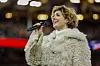 Sissel Kyrkjebø synger i mikrofon foran publikum på Ullevaal Stadion før landskampen.