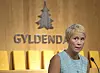Kari Marstein står ved en talerstol foran Gyldendal-logoen under presentasjonen av høstlisten.