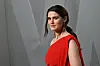Inga Ibsdotter Lilleaas i rød kjole foran en grå bakgrunn på Vanity Fair Oscar Party.