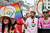 Folk går i Pride-paraden i Oslo med regnbueflagg og fargerike klær.