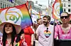 Folk går i Pride-paraden i Oslo med regnbueflagg og fargerike klær.