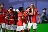 Norske fotballspillere i røde og hvite drakter feirer foran tribunene etter scoring.