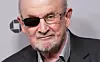 Salman Rushdie med briller og øyelapp foran en grå vegg på Sundance-premieren.