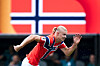 Erling Braut Haaland løper i rød Norge-drakt foran et stort norsk flagg under VM-kamp i New Jersey.