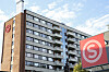 Rekke med studentboliger på Kringsjå i Oslo med røde logoer på fasaden under oppussing.
