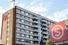 Rekke med studentboliger på Kringsjå i Oslo med røde logoer på fasaden under oppussing.