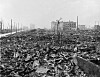 Svarthvitt bilde av ruinene i Hiroshima etter atombomben, med ødelagte bygninger og sønderrevet terreng.