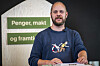 Mimir Kristjánsson står ved en talerstol foran skilt med teksten «Penger, makt og framtid».