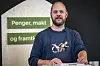 Mimir Kristjánsson står ved en talerstol foran skilt med teksten «Penger, makt og framtid».