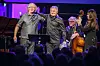 To prisvinnere står på scenen sammen med musikere under et arrangement i Oslo.