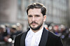 Kit Harington i svart smokingjakke poserer foran fotografer i London.