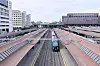 Tog på sporet mellom plattformene ved Oslo sentralstasjon, med bybebyggelse i bakgrunnen.