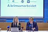 To representanter sitter ved et pressebord under en presentasjon av A-krimsamarbeidet.