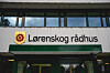Fasaden på Lørenskog rådhus med kommunens logo og navn over inngangen.
