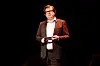 Finn Tokvam står i mørket på scenen og holder kort under Brageprisen 2013.