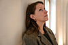 Portrett av Susanne Sundfør som lener seg mot en vegg og ser opp mot lyset.
