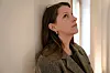 Portrett av Susanne Sundfør som lener seg mot en vegg og ser opp mot lyset.