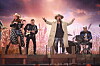 Lasse Stefanz opptrer på scenen med vokalist i hatt, gitarister og trommeslager.