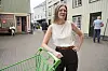 Marie Sneve Martinussen står med en grønn handlevogn i en gate i Arendal.