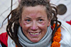 Kristin Harila smiler nær kameraet med grått skjerf og oransje blomsterkrans.